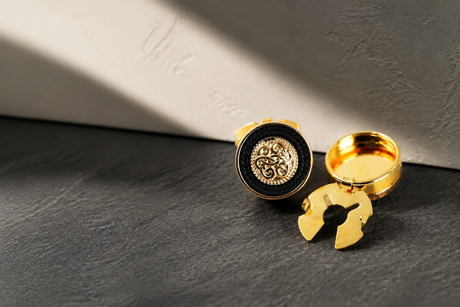 Black and gold metal button covers on charcoal stone